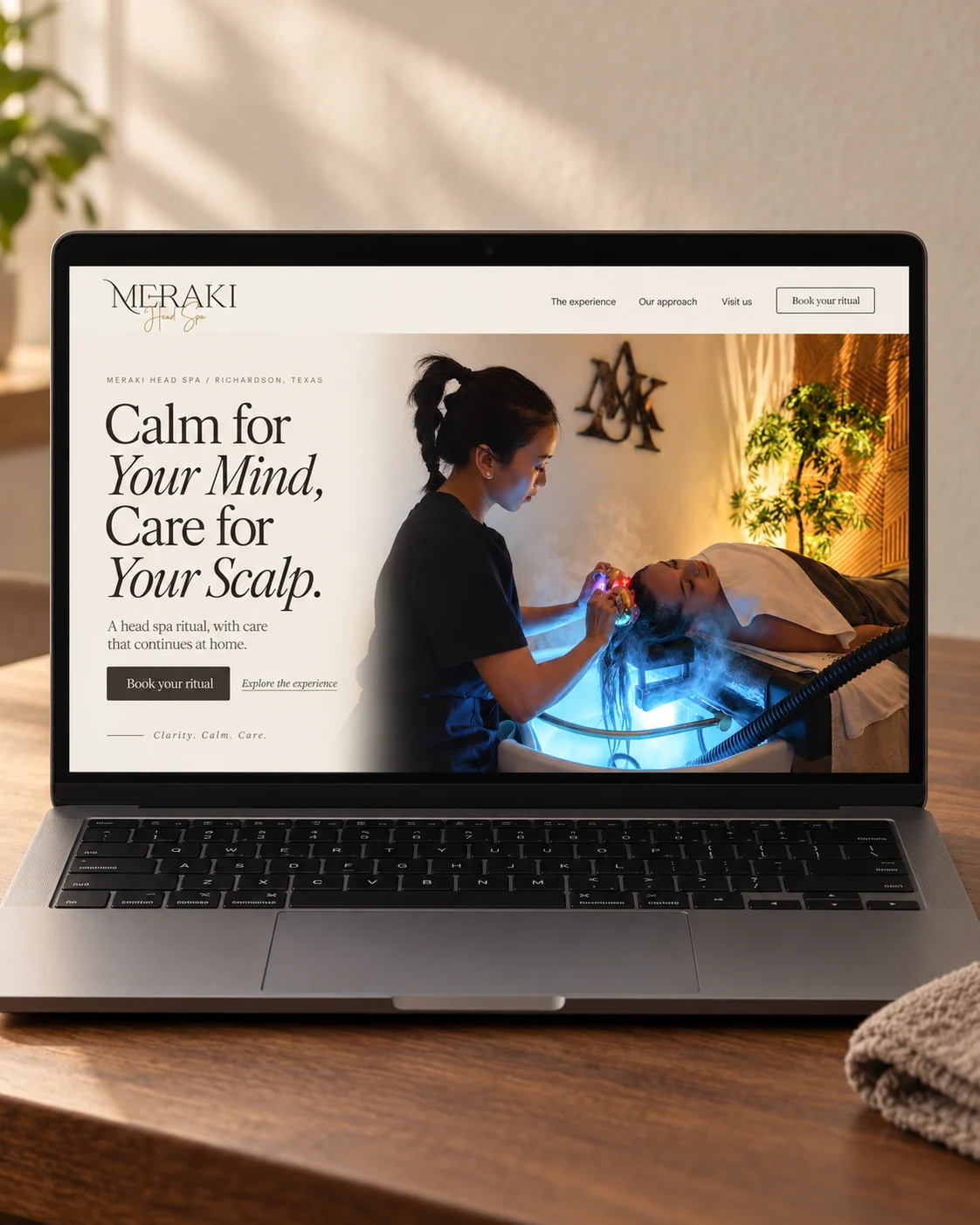 Meraki Head Spa website design concept shown on a laptop in a warmly lit setting.